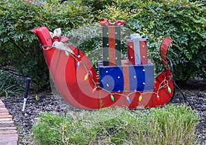 Red steel Christmas sleigh with gifts and lights in Greenbrier Park, University Park, Dallas, Texas. photo