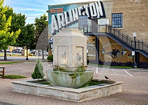 Replica fountain in front of `Historic Arlington` mural on the historic Vandergriff Office Building in Arlington, Texas.