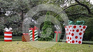 Sculptures of large Christmas gifts with bows and an undecorated Christmas tree before a mansion in Highland Park, Dallas, Texas photo