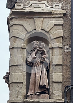 Statue of Saint Anthony of Padua in a niche on Via Urbana in Bologna, Italy.
