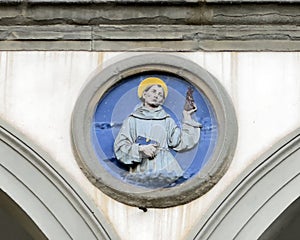 Terracotta relief of a Franciscan saint by Andrea della Robbia in a spandrel of the Hospital of San Paolo in Florence, Italy.