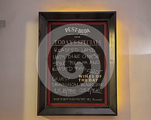 Humorous quote about wine on `Today`s Specials` sign inside historic Pest-Buda Bistro, Hungary