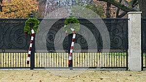 Two Chistmas candy canes hanging from green wreathes decorating a fence in Dallas, Texas photo