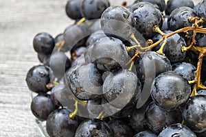 Pictures of black grapes on a wooden floor, black and green grapes pictures in the plate, the great black grapes