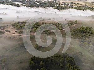 Pictures of the drone flight over the fog. River, forest, fields and meadows on a misty summer dawn. Summer