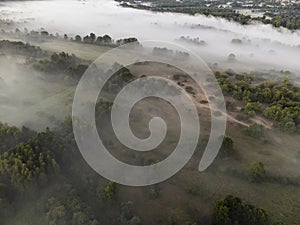 Pictures of the drone flight over the fog. River, forest, fields and meadows on a misty summer dawn. Summer