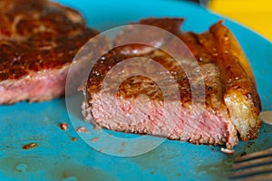 Pictures of a sliced fresh rump steak  with fat on the steak on a plate and a fork