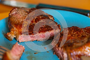 Pictures of a sliced fresh rump steak  with fat on the steak on a plate and a fork