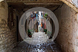 Picturesque arch with a colorful street at the background in the old town of Rovinj, Croatia