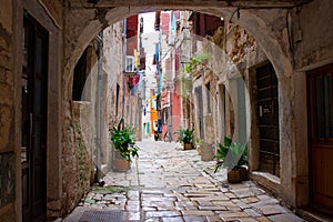 Picturesque arch with a colorful street at the background in the old town of Rovinj, Croatia