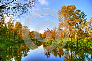 Picturesque autumn landscape of steady river and bright trees photo