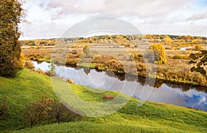 Picturesque autumn landscape with trees, river and sky