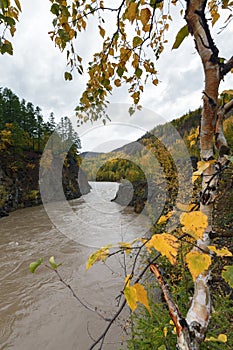 Picturesque autumn river flowing among roky mountain