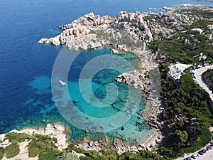 Picturesque beach with a line of boats moored at the water's edge in Sardinia, Italy.