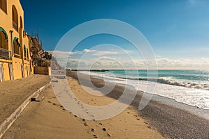 Picturesque beach with sandy terrain and footprints along the shoreline in Varigotti, Liguria, Italy