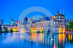 Picturesque Binnenhof Palace of Parliament inThe Hague in The Netherlands At Dusk. Against Modern Skyscrapers on Background