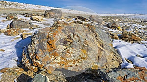 Picturesque boulders. Close-up. Snow in a boundless valley. Blue sky. Altai