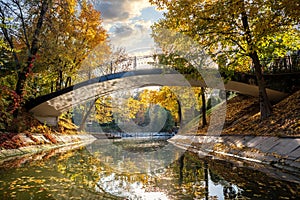 Picturesque bridge across the autumn lake in Almaty Gorky Park, Kazakhstan