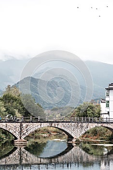 Picturesque bridge spanning across a tranquil body of water: Hongcun, China