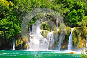 A picturesque cascade waterfall among large stones in the Krka National Landscape Park, Croatia in spring or summer. The beautiful