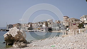 Picturesque cityscape of Albanian city of Sarande on coast of Ionian Sea overlooking modern residential area with houses