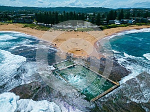 Picturesque coastline view of a beach town featuring rolling waves and shoreline,Mona Vale Rock Pool