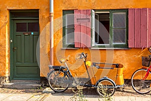 Picturesque of Copenhagen. Old yellow house of Nyboder district with bikes. Old Medieval district in Copenhagen, Denmark
