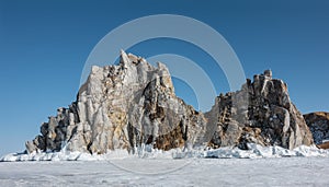 A picturesque double-headed rock rises above the ice of a frozen lake