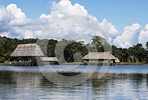 Picturesque and exotic lagoon with clean water El Milagro, loggon milagros with wooden house and thatched roof stilt houses Amazon