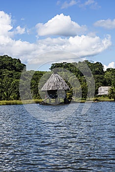 Picturesque and exotic lagoon with clean water El Milagro, loggon milagros with wooden house and thatched roof stilt houses Amazon