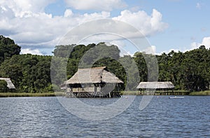 Picturesque and exotic lagoon with clean water El Milagro, loggon milagros with wooden house and thatched roof stilt houses Amazon