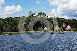 Picturesque and exotic lagoon with clean water El Milagro, loggon milagros with wooden house and thatched roof stilt houses Amazon