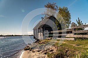 A picturesque fishing house with a washed-out Foundation on the Bank of the Volkhov river at the exit to lake Ladoga