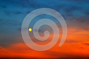 Picturesque Full moon on a background of beautiful blue and red clouds. Clouds at sunset, sunrise during the full moon. Cloud