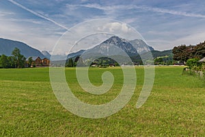 Picturesque green alpine meadow surrounded by mountain peaks