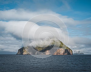 Picturesque green cliffs on Litla Dimun island and atlantic ocean in Faroe islands.