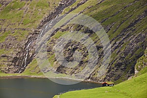 Picturesque green landscape with black house in Faroe islands. Saksun