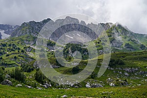 A picturesque green mountain gorge with rocky peaks and lush meadows.