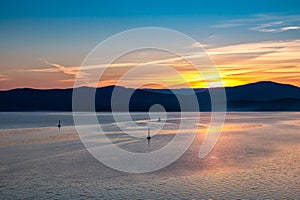 Picturesque lake at sunset where yachts sail