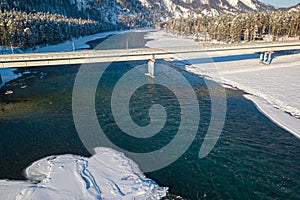 Picturesque landscape in the Altai mountains with snow-capped peaks under a blue sky with clouds in winter with green river and