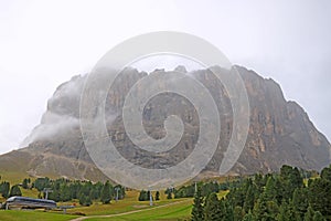 Picturesque landscape of foggy morning in mountain village in Dolomites Alps, selective focus