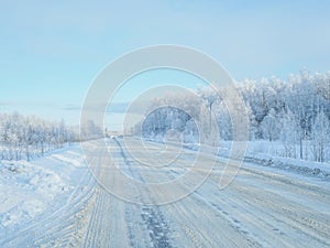 A picturesque landscape with frost-covered trees on the edge of the road.