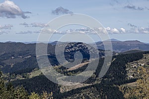 a picturesque landscape with verdant forests on rolling hills under a partly cloudy sky