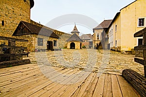 Picturesque landscape view of courtyard with ancient stone buildings in the old medieval castle. High stone wall background