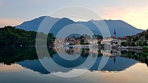Picturesque little lakeside village Mergozzo at sunset, beautiful reflection in the water. Piedmont, Northern Italy.