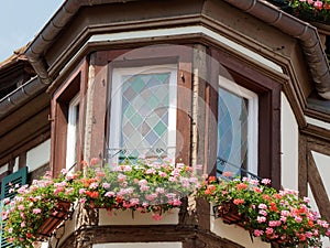 Picturesque medieval house with geraniums on the window sill