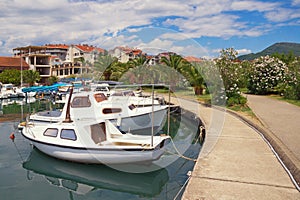 Picturesque Mediterranean landscape. Embankment of seaside town, with view of fishing boats in harbor. Montenegro, Tivat city