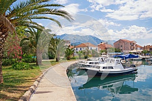 Picturesque Mediterranean town embankment with view of fishing boats in harbor. Montenegro, Tivat city