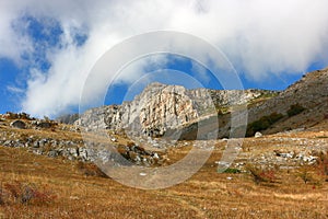 Picturesque mountain rocky peak and surrounding mountain landscape on a sunny autumn day.