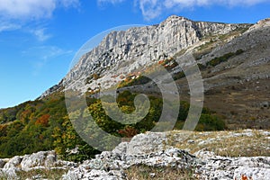 Picturesque mountain rocky peak and surrounding mountain landscape on a sunny autumn day.